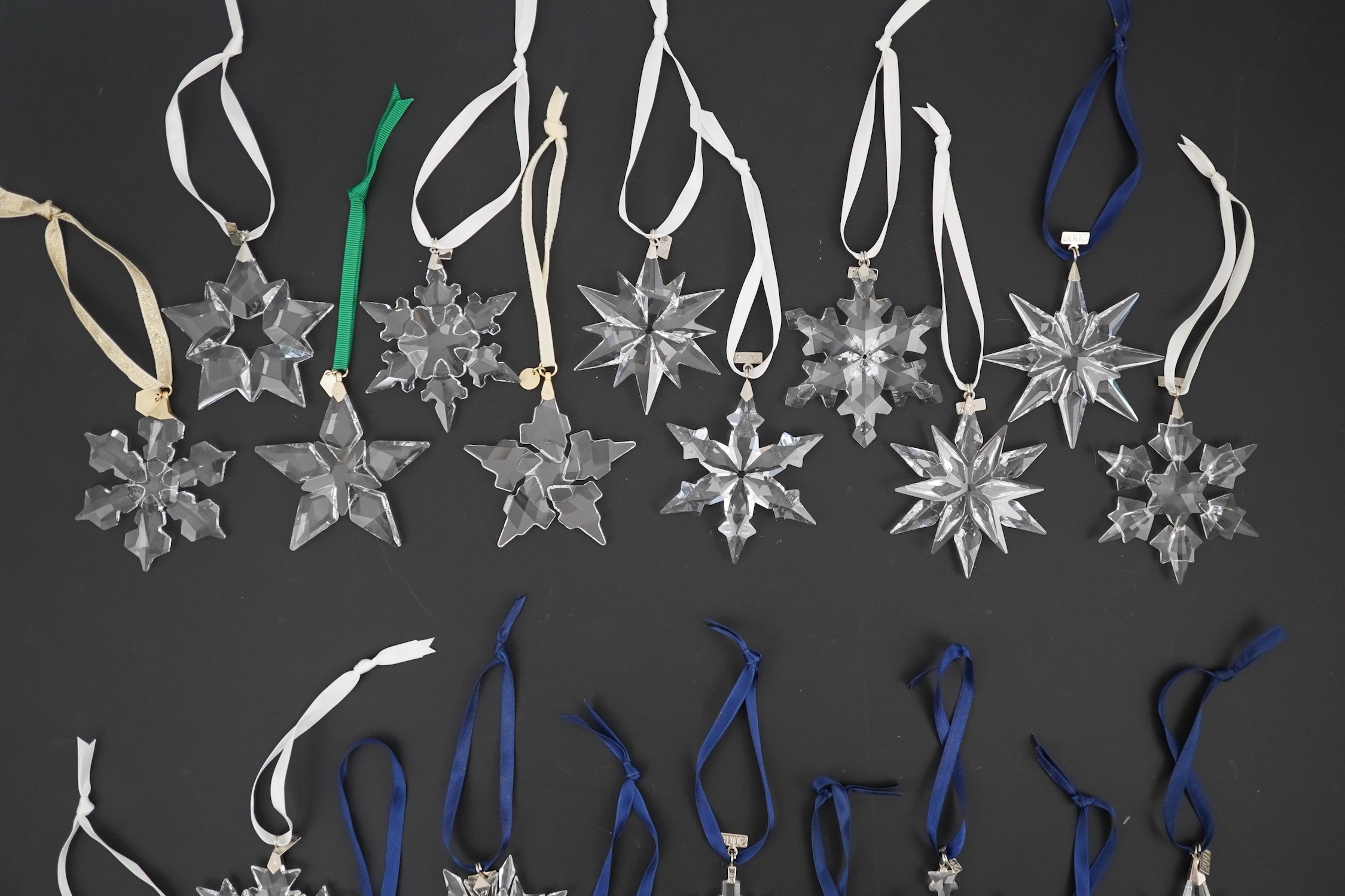Twenty one Swarovski Christmas stars with hanging ribbons and date charms, No boxes but otherwise in all good in condition